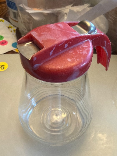 Glass syrup dispenser with red plastic spring-loaded lid by Federal Tool Corp.