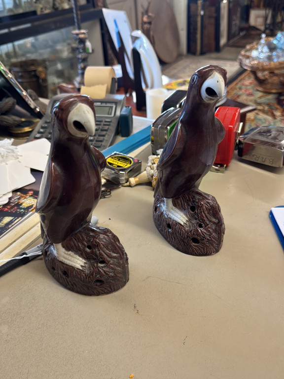 Glazed ceramic parrot figurines on rockwork bases