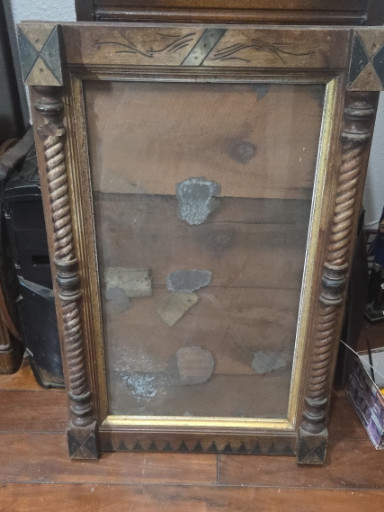 Wooden wall-mounted display cabinet with carved spiral columns and decorative pediment