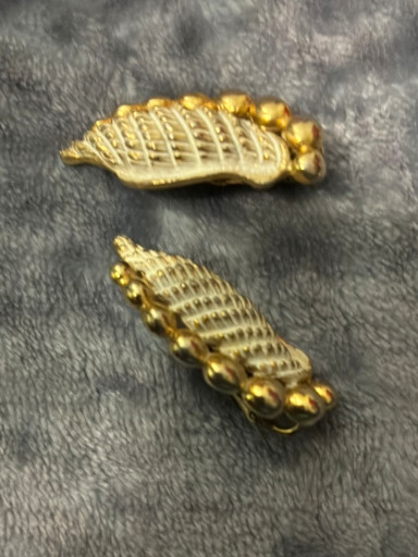 Gold-tone metal clip-on earrings in a ribbed shell or leaf design