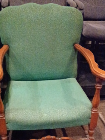 Upholstered armchair with carved wooden frame and green fabric