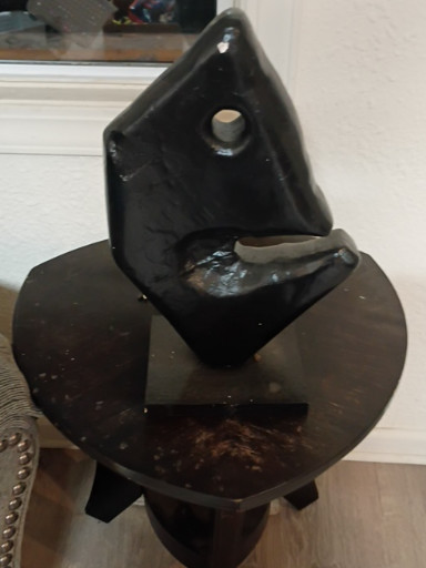 Hand-carved obsidian sculpture depicting an abstract face or mask