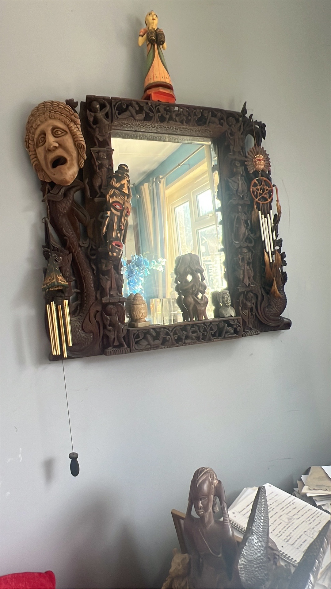 Carved wooden Southeast Asian decorative mirror with tribal masks and figurines