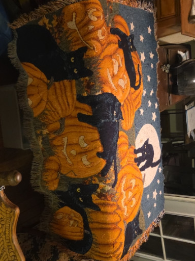 Cotton woven throw blanket with Halloween motif featuring black cats and pumpkins