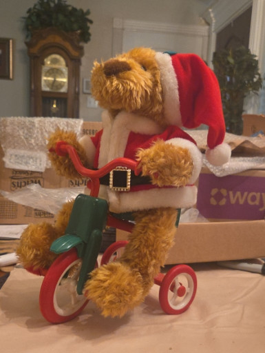 Plush mechanical toy titled '1997 Avon Cycling Santa Bear' by Avon Products