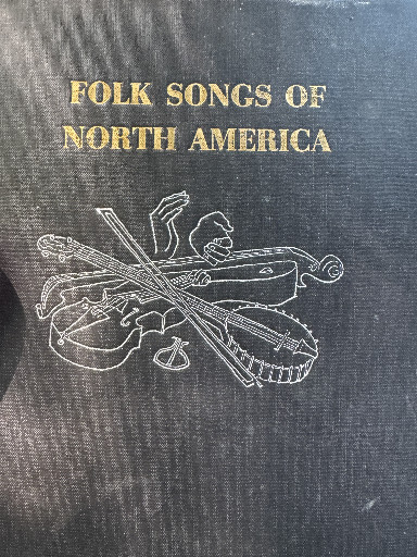 Book titled 'Folk Songs of North America' with decorative musical instrument cover design