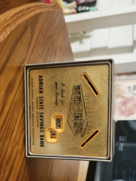 Metal advertising savings bank calendar from Adrian State Savings Bank