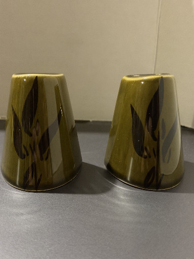 Pair of mid-century modern ceramic salt and pepper shakers with olive green glaze and abstract leaf motif