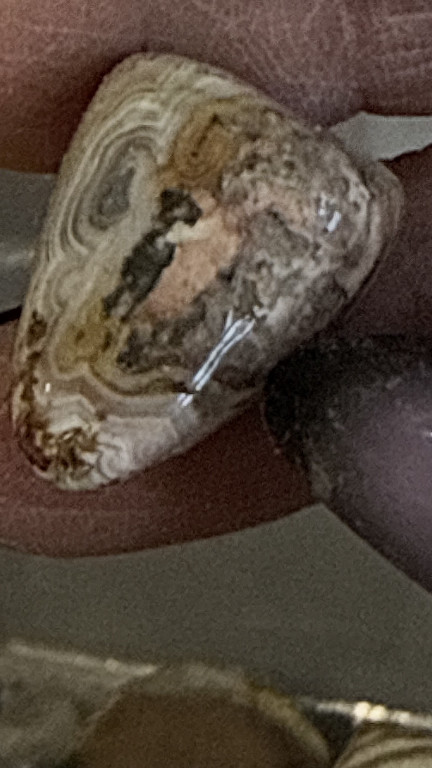 Polished agate stone specimen with banded fortification patterns