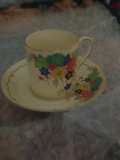 Porcelain teacup and saucer with hand-painted floral decoration