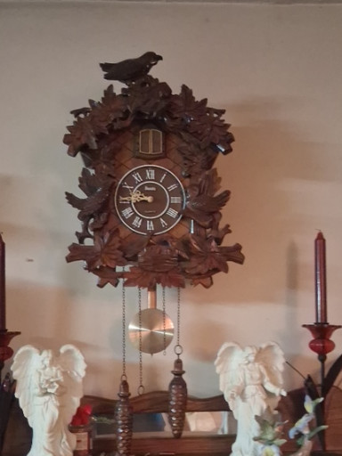 Hand-carved wooden cuckoo clock with leaves, birds, and nest