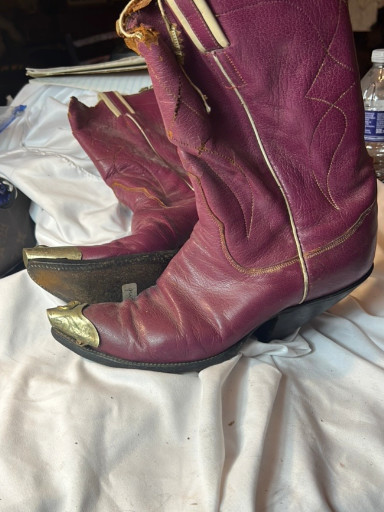 Vintage burgundy leather cowboy boots with gold stitching and metal toe caps