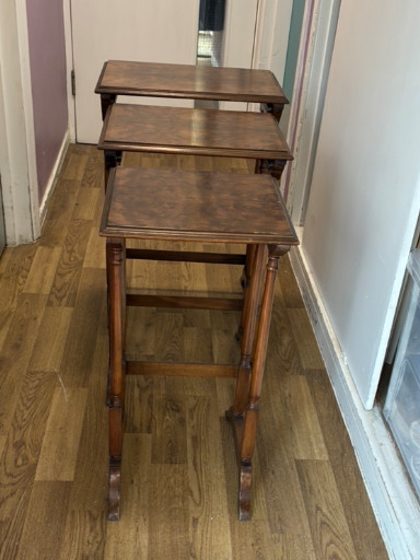 Set of three mahogany nesting tables with turned legs and casters