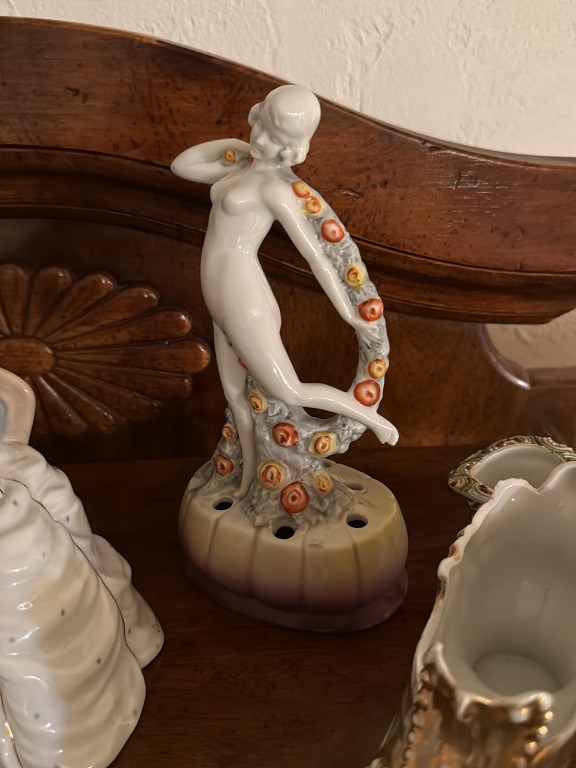 Porcelain flower frog figurine depicting a nude female dancer with floral garland, made in Germany
