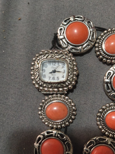 Silver-tone decorative watch with coral-colored cabochon stones
