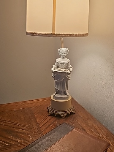 Porcelain figurine table lamp depicting a Victorian-era woman holding flowers