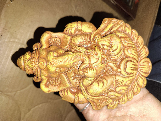 Resin sculpture of Lord Ganesha seated on a peepal leaf