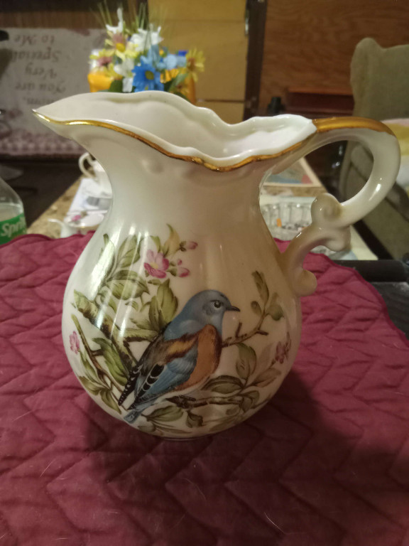 Porcelain pitcher with hand-painted bird and floral decoration with gold trim