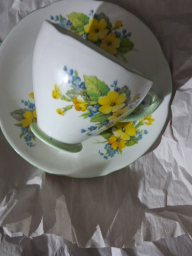 Bone china teacup and saucer with yellow primrose and blue forget-me-not floral pattern, likely by Bell China or Standard China, England