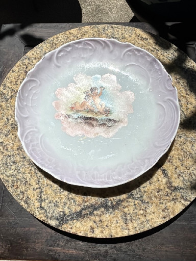 Porcelain decorative plate with cherub motif and scalloped edges