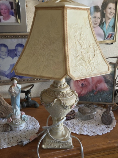 Ceramic table lamp with lithophane shade featuring pastoral scenes and ornate cherub-decorated base