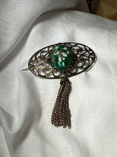 Vintage filigree brooch with green glass cabochon and chain tassel
