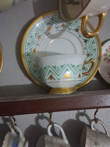 Porcelain demitasse cup and saucer with green geometric Art Deco pattern and gold trim