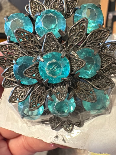 Vintage costume jewelry brooch with turquoise glass rhinestones and antiqued metal filigree