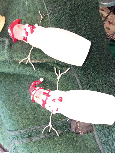 Pair of decorative Christmas snowman figurines with white bodies, red scarves, and twig arms