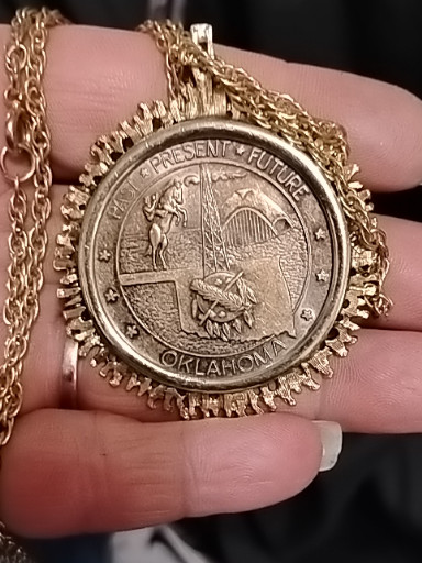 Gold-tone metal pendant featuring the 1973 Official Oklahoma Bicentennial Medallion