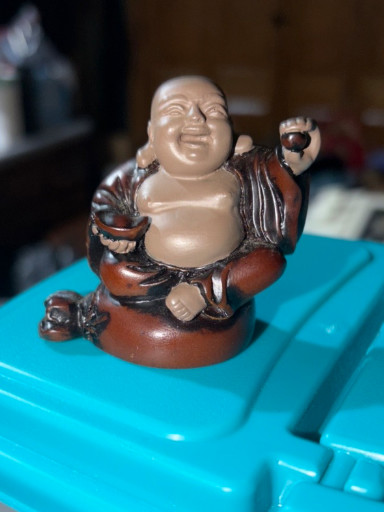 Carved wooden figurine of Budai (Laughing Buddha) seated on a sack
