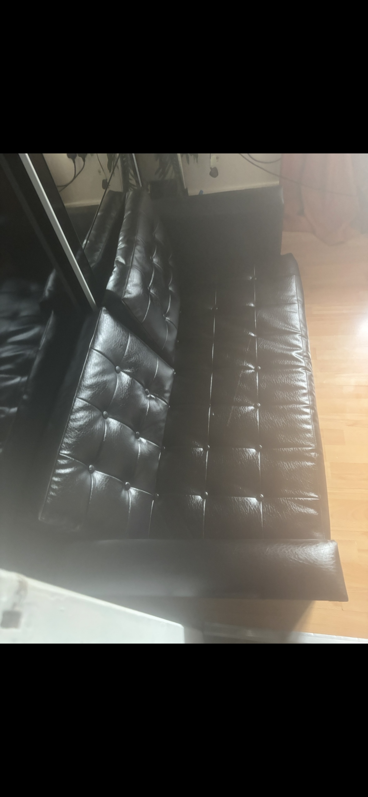 Black leather tufted sofa