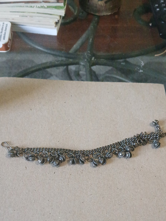 Silver charm bracelet with multiple small dangling ornaments