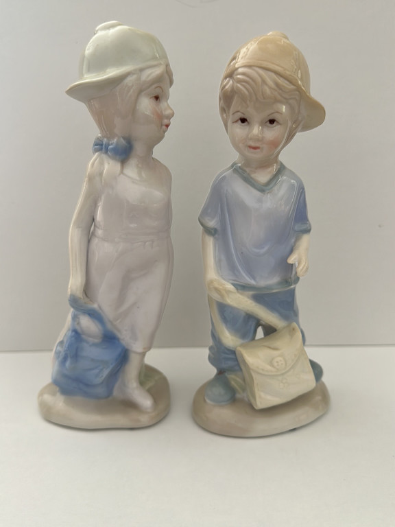 Porcelain figurines of children with bags in blue and white attire