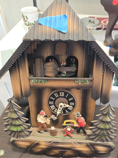Wood chalet-style cuckoo clock with animated woodcutter figures