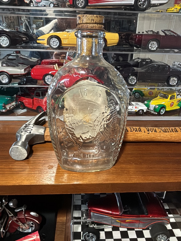 Glass commemorative bottle titled 'Log Cabin Syrup 1776-1976 Bicentennial' by Metro Bottle Company