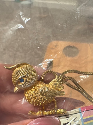 Gold-tone metal bird brooch with articulated chain tail