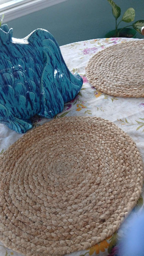 Handwoven natural fiber round placemats, likely water hyacinth or jute