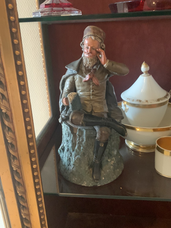 Figurine en terre cuite polychrome représentant un homme âgé assis sur une souche