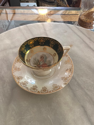 Porcelain demitasse cup and saucer set with portrait medallion and gilt decoration