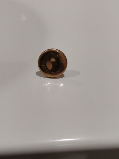 Brass military or uniform button with central hole, likely early 20th century