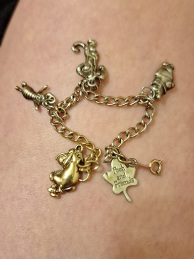 Vintage goldtone charm bracelet with Disney-themed charms including mouse, clover, and figural charms