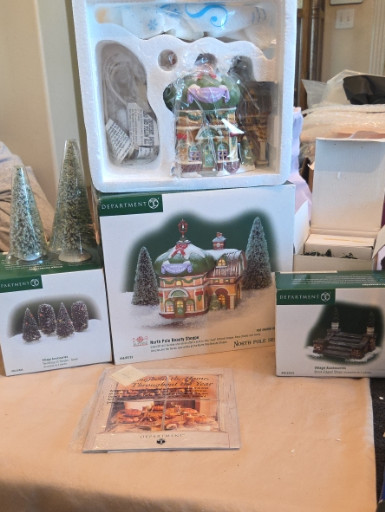 Ceramic lighted building set titled 'North Pole Beauty Shoppe' by Department 56, including accessory trees, shrubs, and brick-edged steps