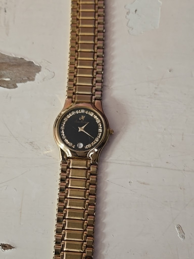 Gold-tone stainless steel quartz wristwatch with black dial and diamond hour markers