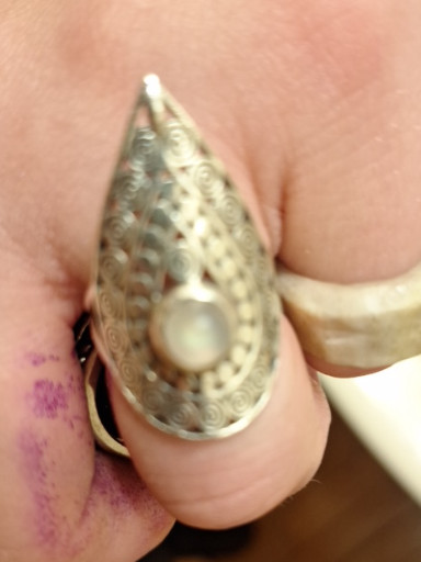 Gold-tone teardrop-shaped locket ring with engraved filigree pattern and central pearl