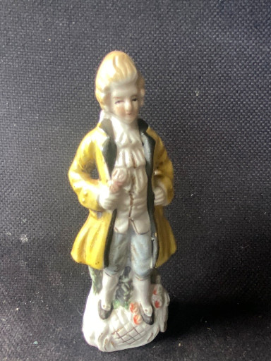 Porseleinen beeldje van een heer in Rococo-stijl met gele jas