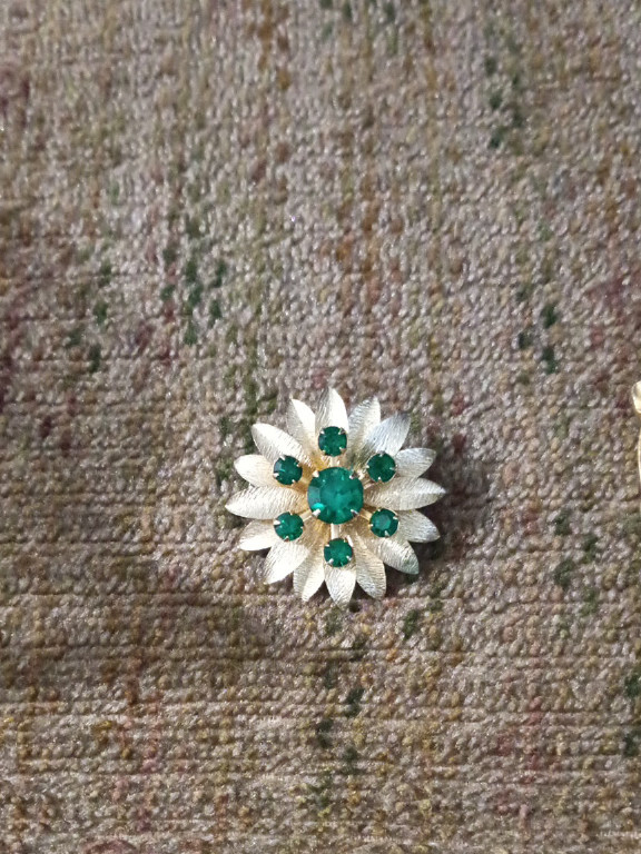 Gold-tone metal brooch with green rhinestones in floral design