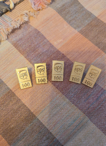 Set of five gold-plated commemorative pins featuring UPS logos and '100' marking the company's centennial anniversary