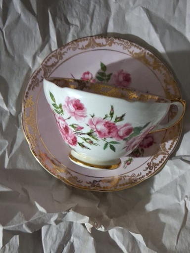 Bone china teacup and saucer with hand-painted pink roses and gold trim