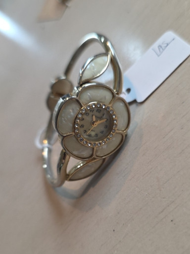 Silver-tone metal bangle watch with flower design and crystal accents by Studio